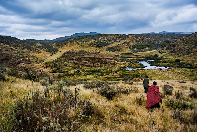 Ours. Olmoti Crater, near Munge River Ngorongoro CA, Highlands with Masai guide wearing traditional red blanket and official ranger 