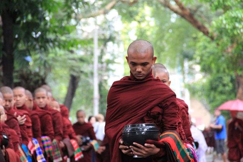 Buddhist monk carrying ceremonial pot