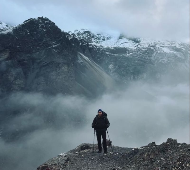 Male trekker high up in mountain on Annapurna Circuit, snow and mist