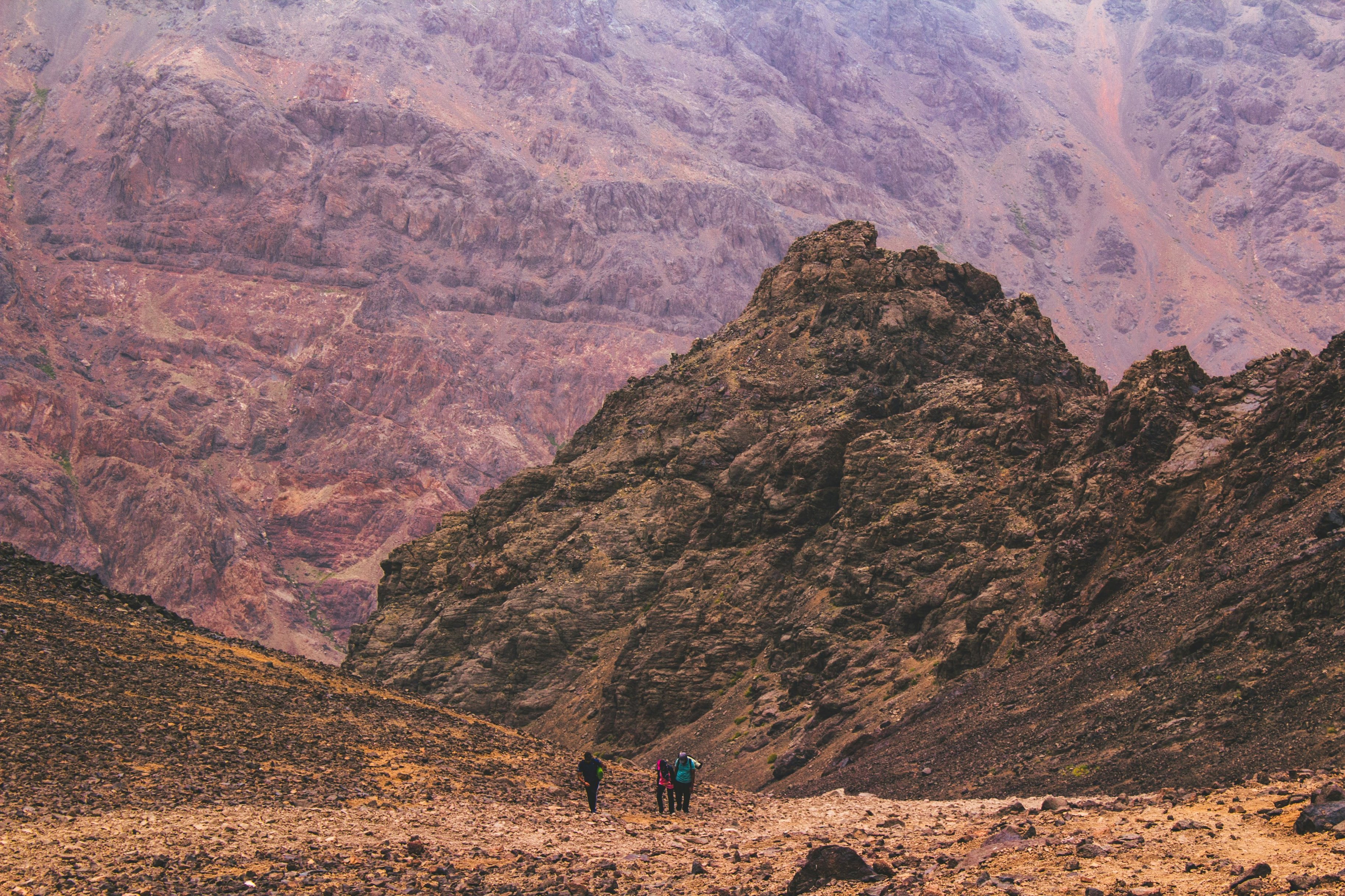 Trekkers climbing Mount Toubkal in alpine desert band of Atlas Mountains of Morocco