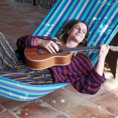 Jess in a hammock with a guitar