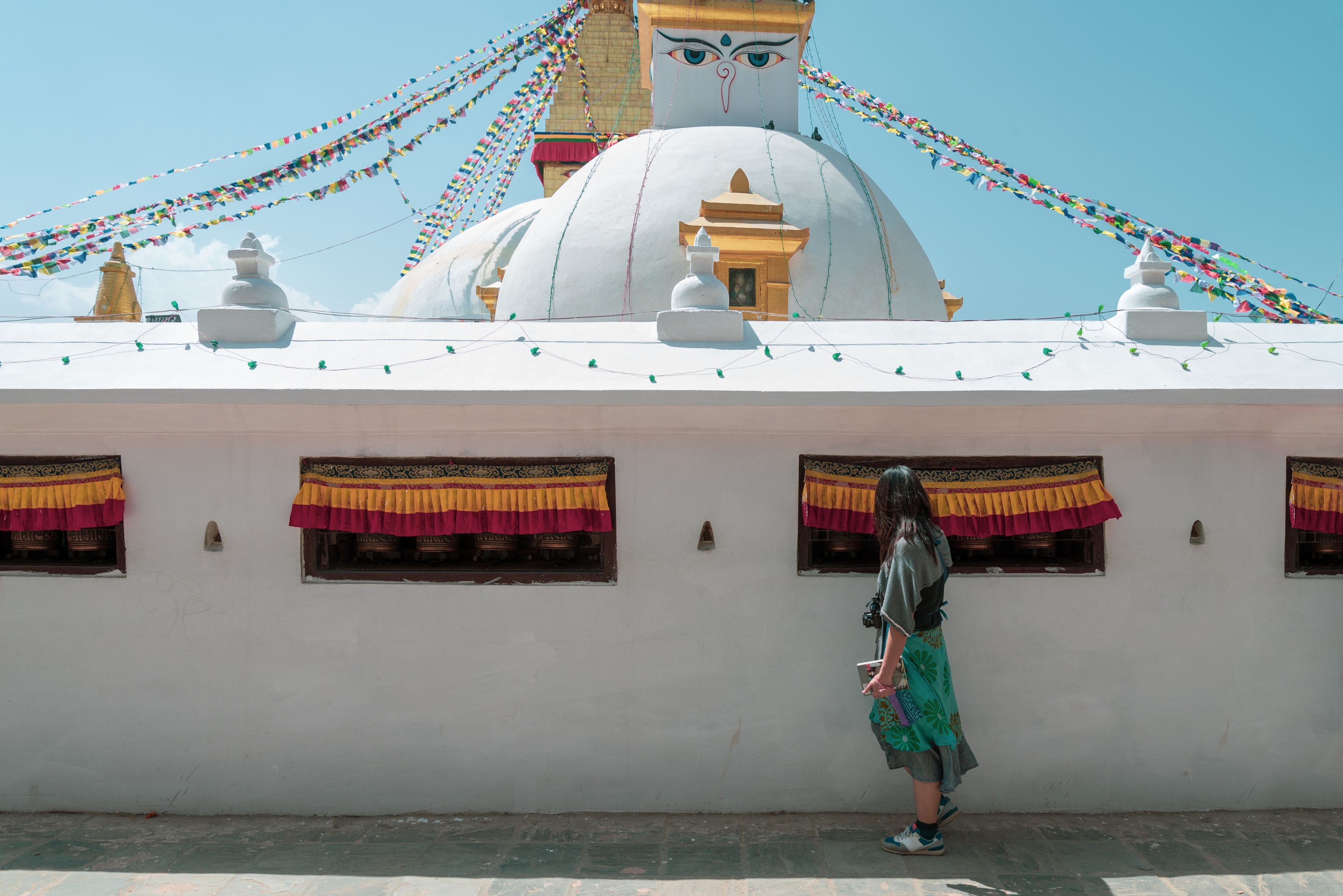 women tourist touch the bell inside the wall of Boudhanath Stupa and praying get blessing at Kathmandu, Nepal