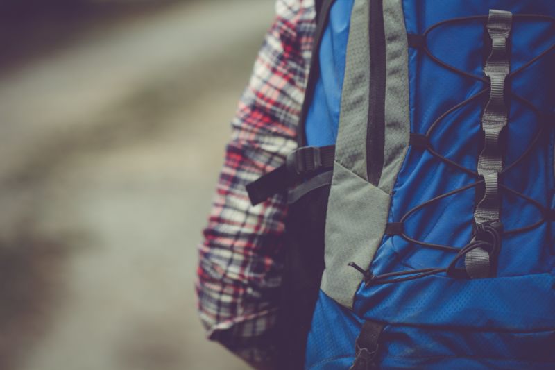 Close up of man wearing blue backpack, shock cord and side pocket