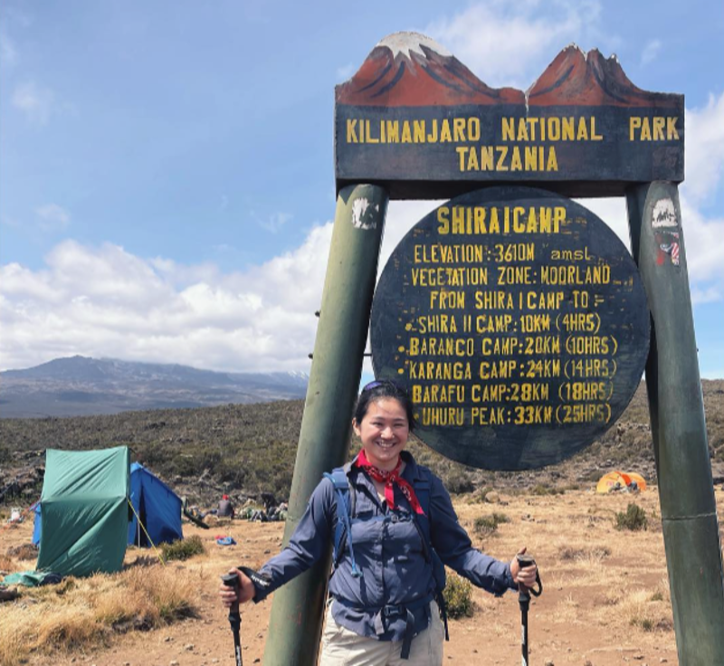 Female hiker by Shira 1 Camp sign on Kilimanjaro, August 2022