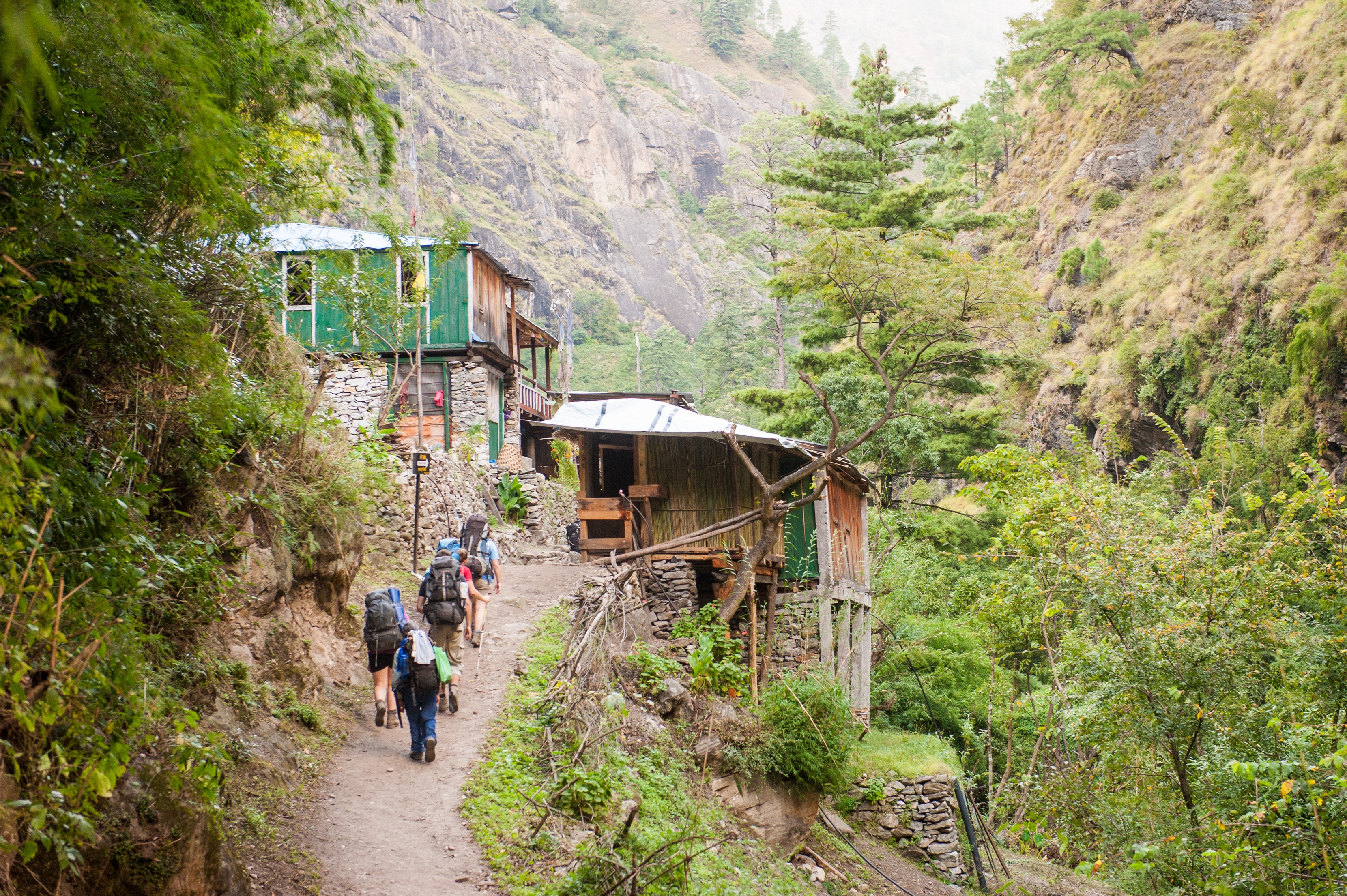 Steep valley and village among trees on Manaslu Circuit trek in Himalayas of Nepal