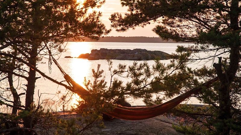 Sweden kayak adventure hammock on island at sunset