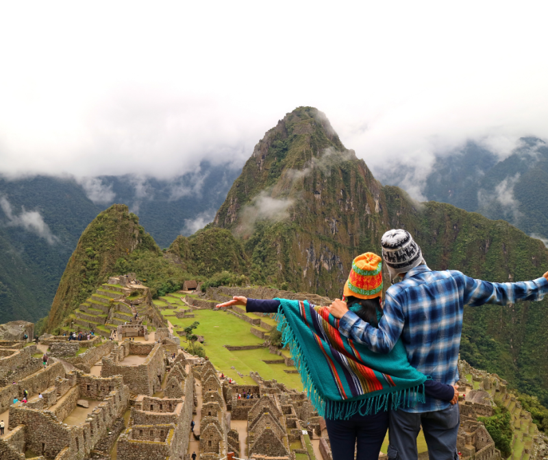Man and woman hugging while looking out over Machu Picchu, Peru