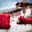 Tibetan Buddhist monks in red robes sitting on low wall by Punakha Dzong with jacaranda in bloom