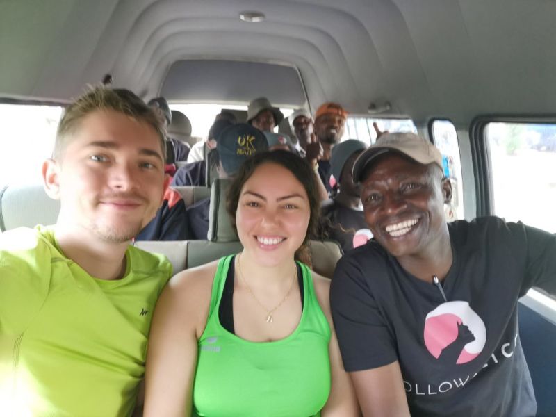 Smiling people in van on way to climb Kilimanjaro