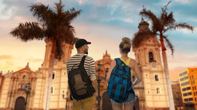 Young couple at sunset in Lima main square, Peru. Colonial building and pam trees