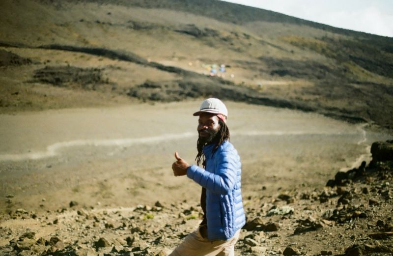 Smiling man giving a thumbs up on Kilimanjaro in alpine desert band
