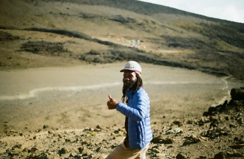Smiling man giving a thumbs up on Kilimanjaro in alpine desert band