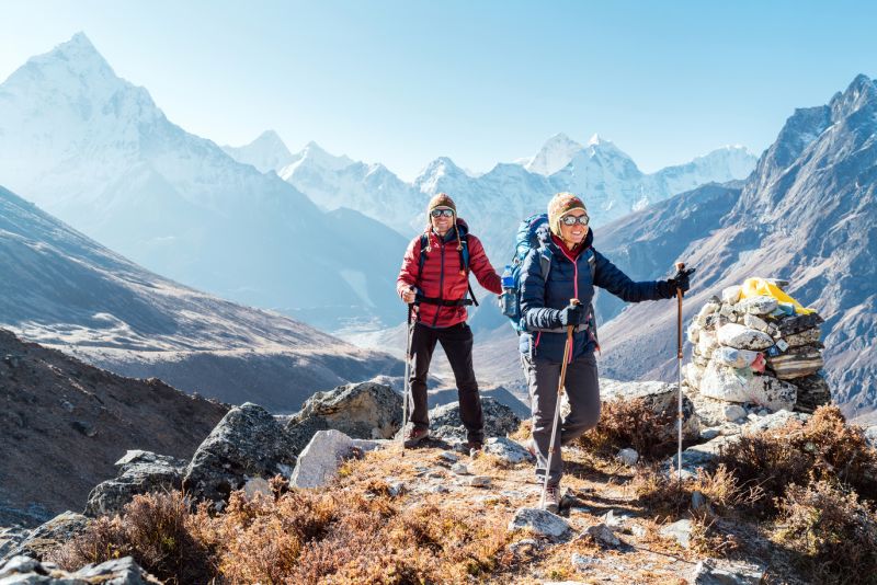 Man and woman trekkers with backpacks and poles on the EBC trek, Nepal