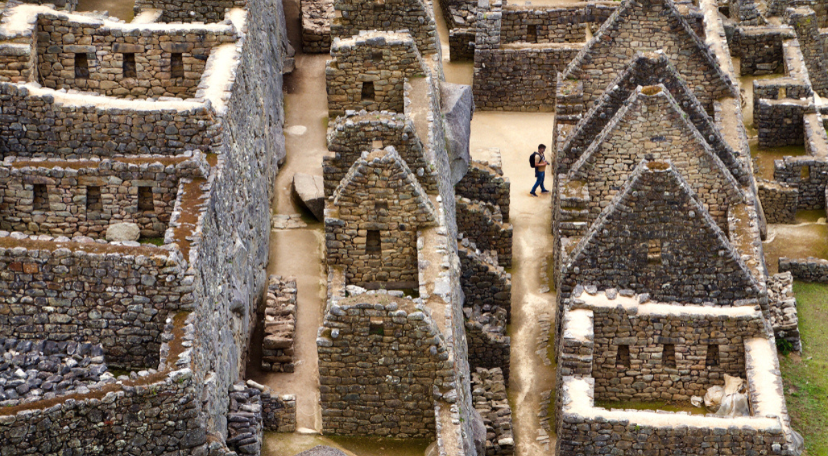 A man wanders through the ruins of the ancient Incan city of Machu Picchu in Peru