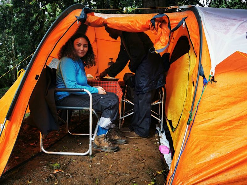 Lady sitting inside small orange tent on Kilimanjaro