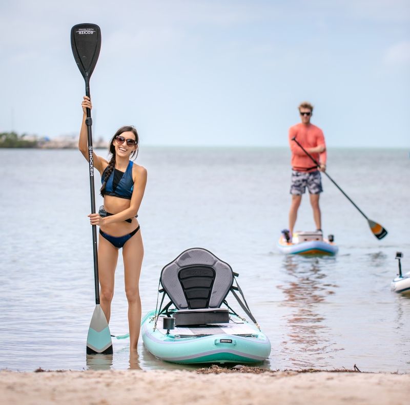 Man and woman paddle skis smiling water