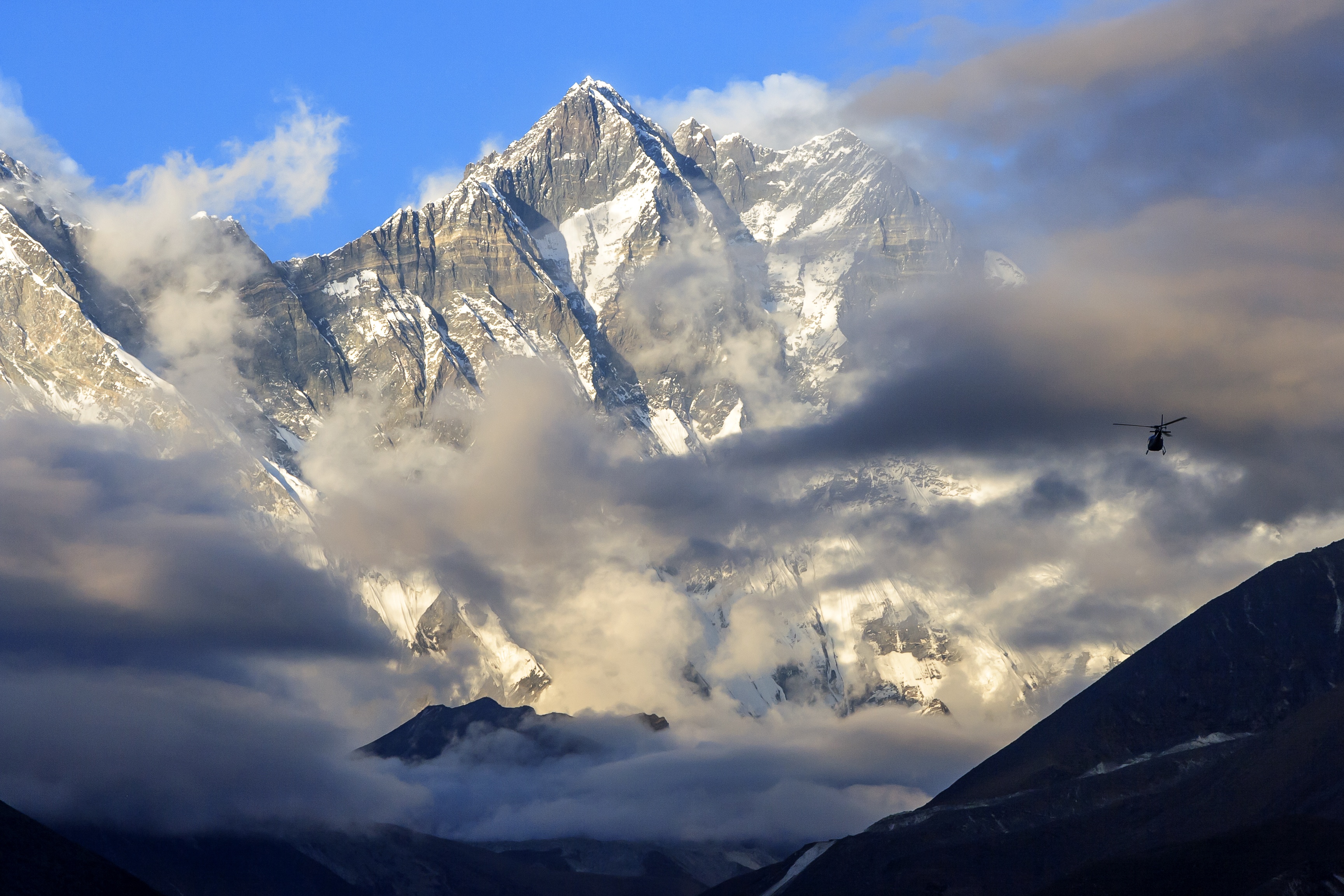 Pur. Helicopter flies past Lhotse mountain, Everest Base Camp trek, Nepal
