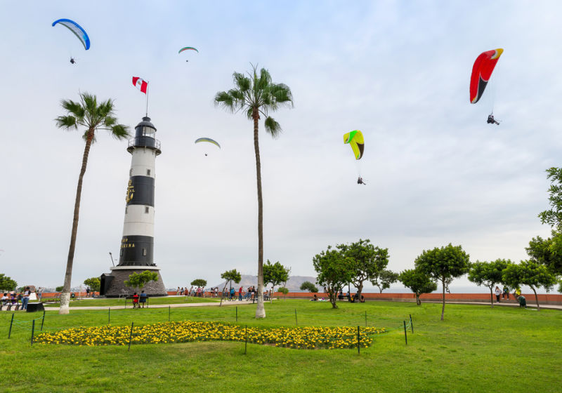 View of La Marina Lighthouse (Faro de La Marina) in Miraflores district, with some paragliders in the sky, in Lima Peru 