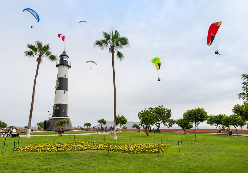 View of La Marina Lighthouse (Faro de La Marina) in Miraflores district, with some paragliders in the sky, in Lima Peru