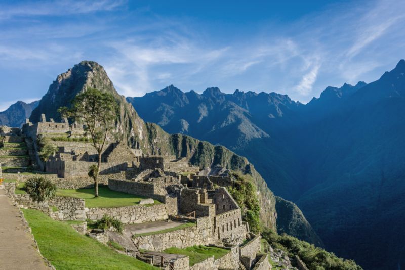 Clear sky and sunny view of Machu Picchu and surrounding mountains of Andes, Peru