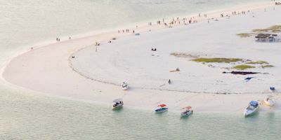 Zanzibar coastline seen from above with boats and dhows and people on beach