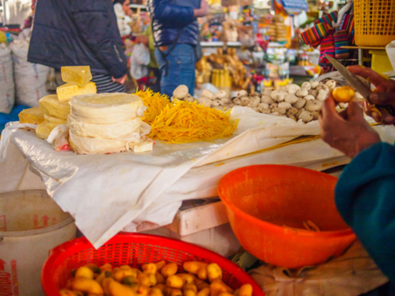 Woman's hands peeling little potatoes in a market stall of Peru, in Cusco