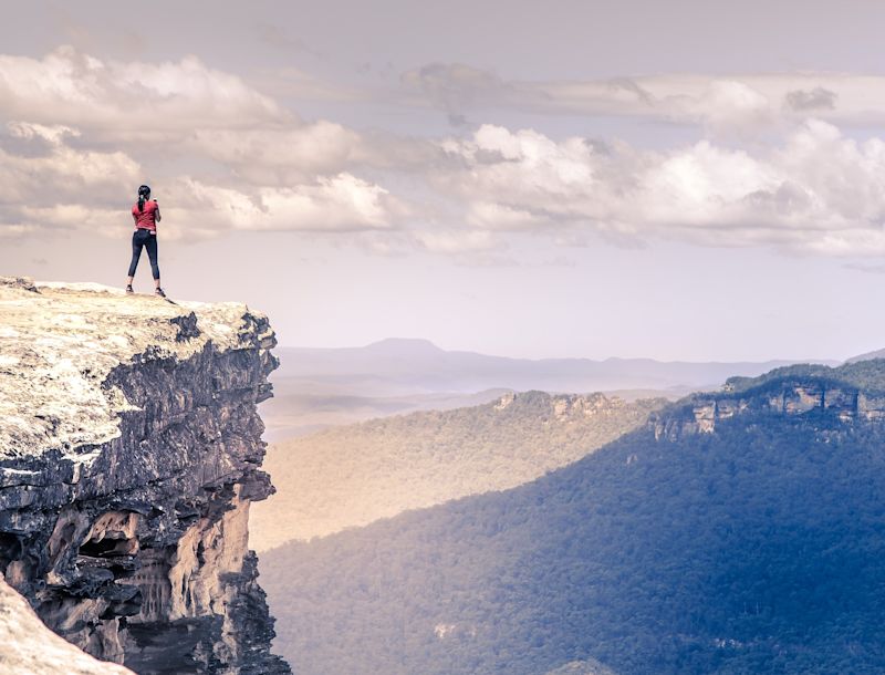 Woman on cliff looking at mountains