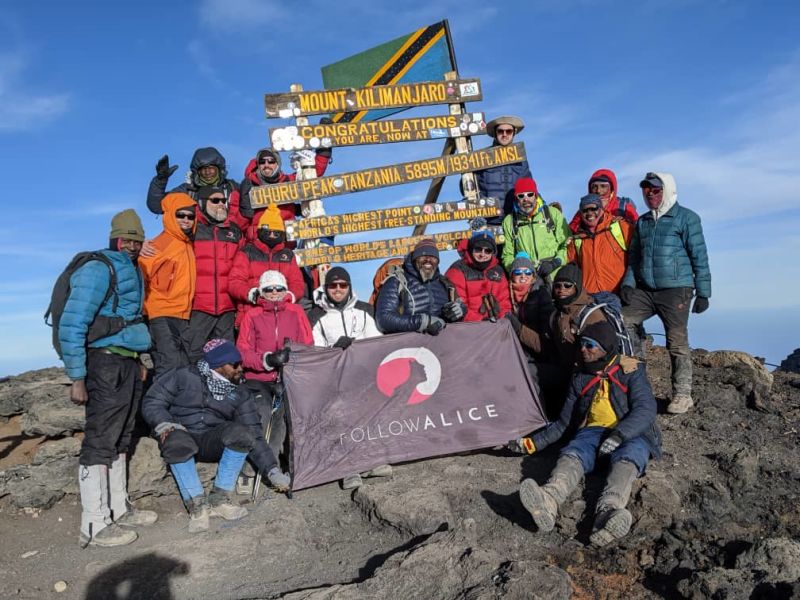 Group pic Kilimanjaro summit Uhuru Peak Follow Alice flag 