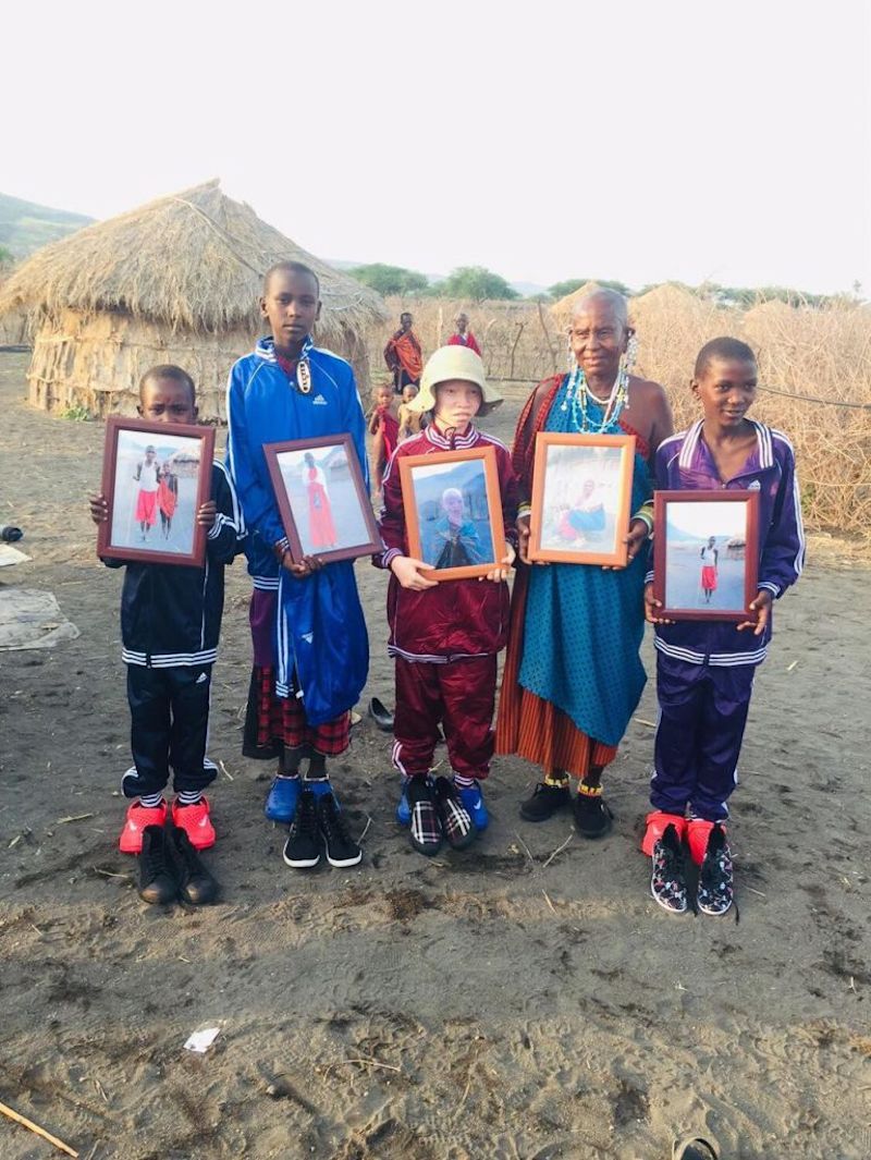 Maasai villagers holding framed photographs, north Tanzania