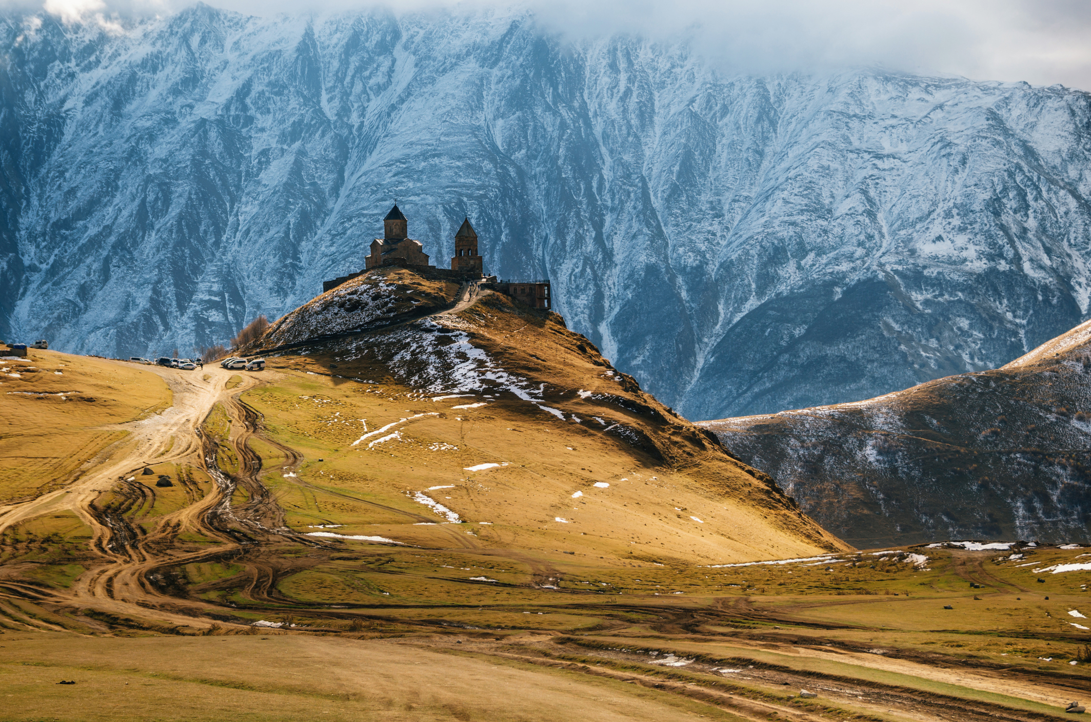 Caucasus mountains, ancient Gergeti Trinity church Tsminda Sameba against the glacier near mount Kazbek, landmark of Georgia