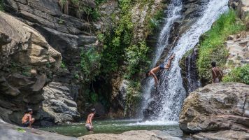 Boys jumping into waterfall in Sri Lanka