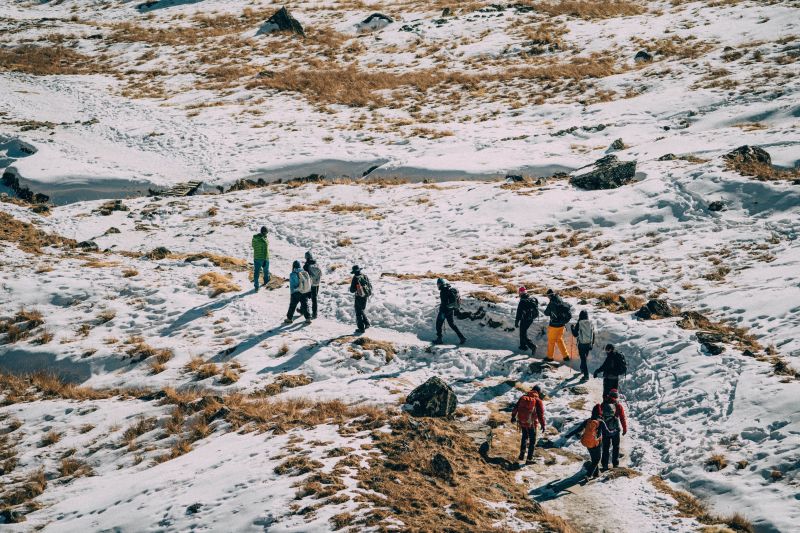 A line of trekkers walks along a trail through the snow on the Everest Base camp route