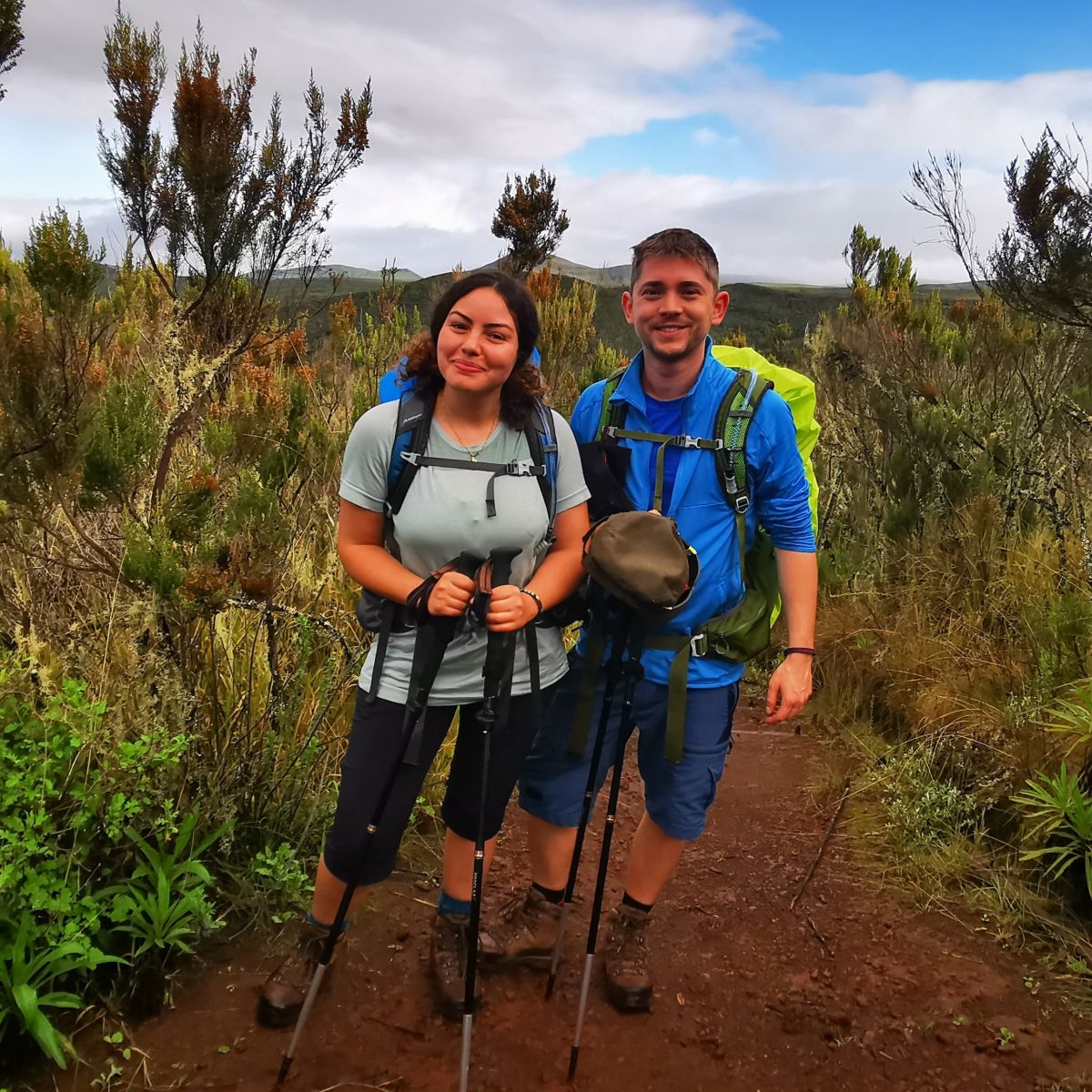 Arwa and Matias in hiking gear and smiling at the camera in the moorland section of Kilimanjaro