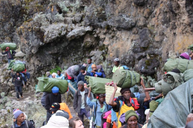 Guides and porters working hard on incline on Kilimanjaro