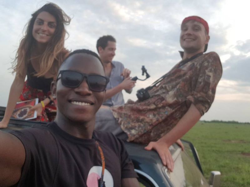 Young adults sitting atop safari vehicle