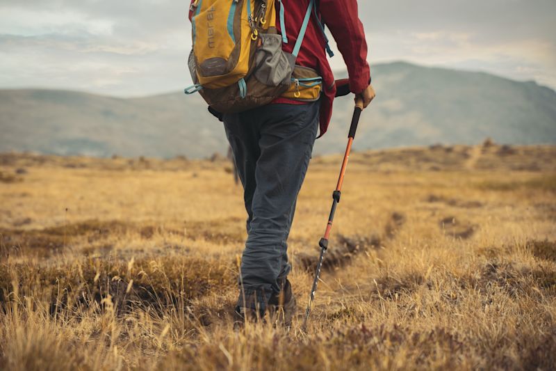 Man with trekking poles using an external level lock system