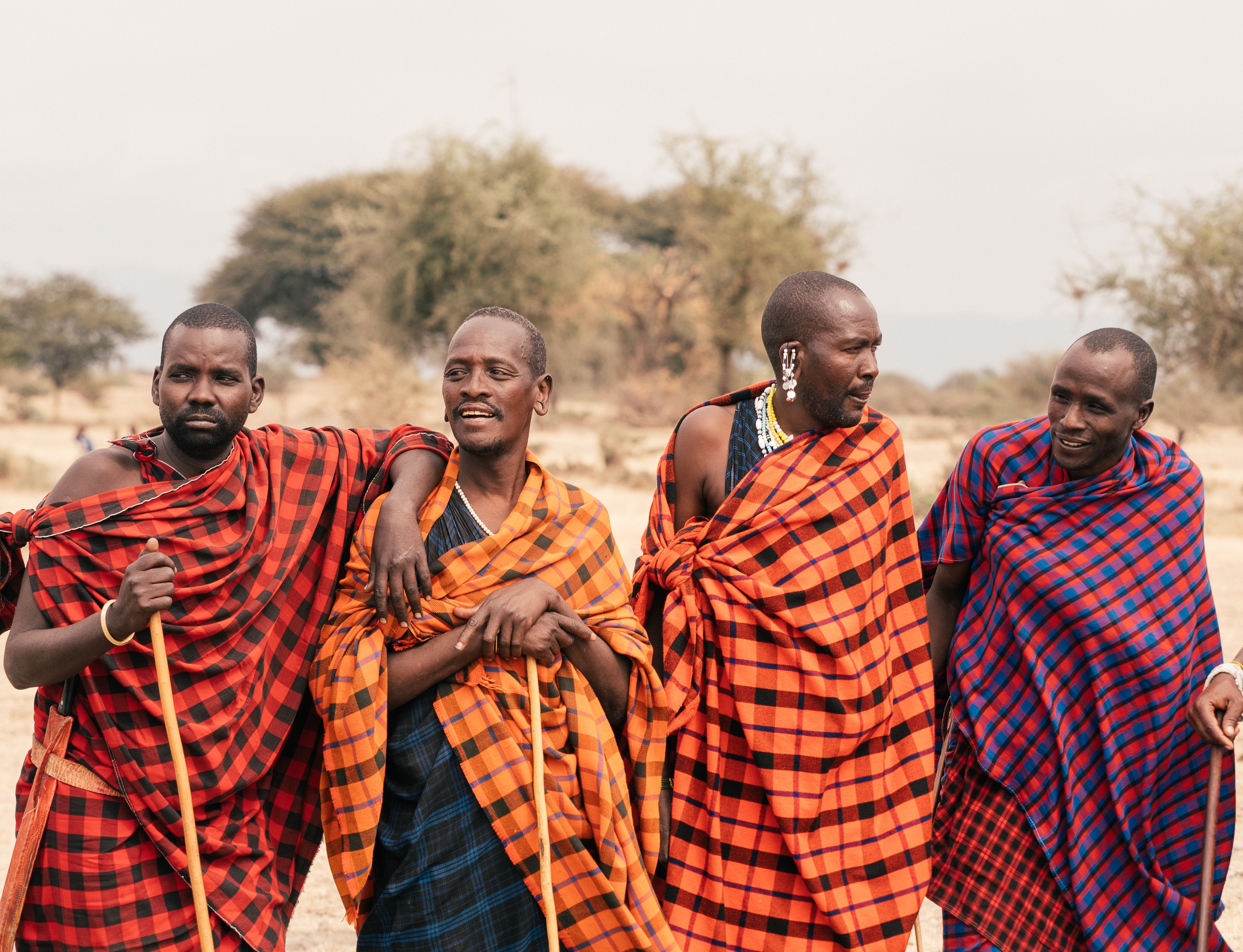 Four Maasai men in traditional robes standing together