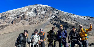 Three ladies taking a selfie at summit with glacier in background