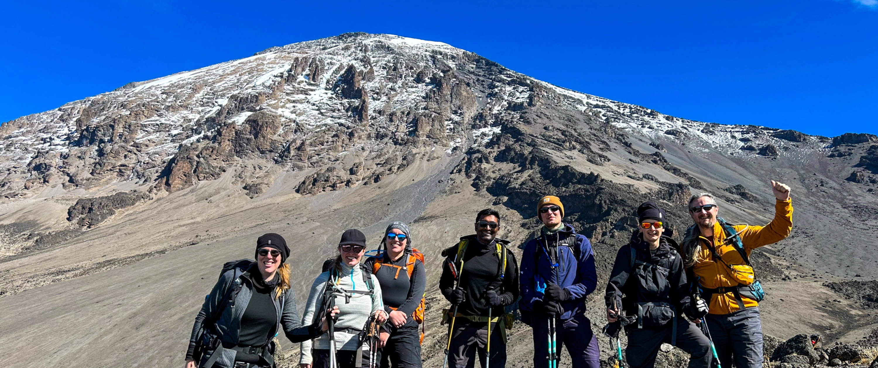 Three ladies taking a selfie at summit with glacier in background