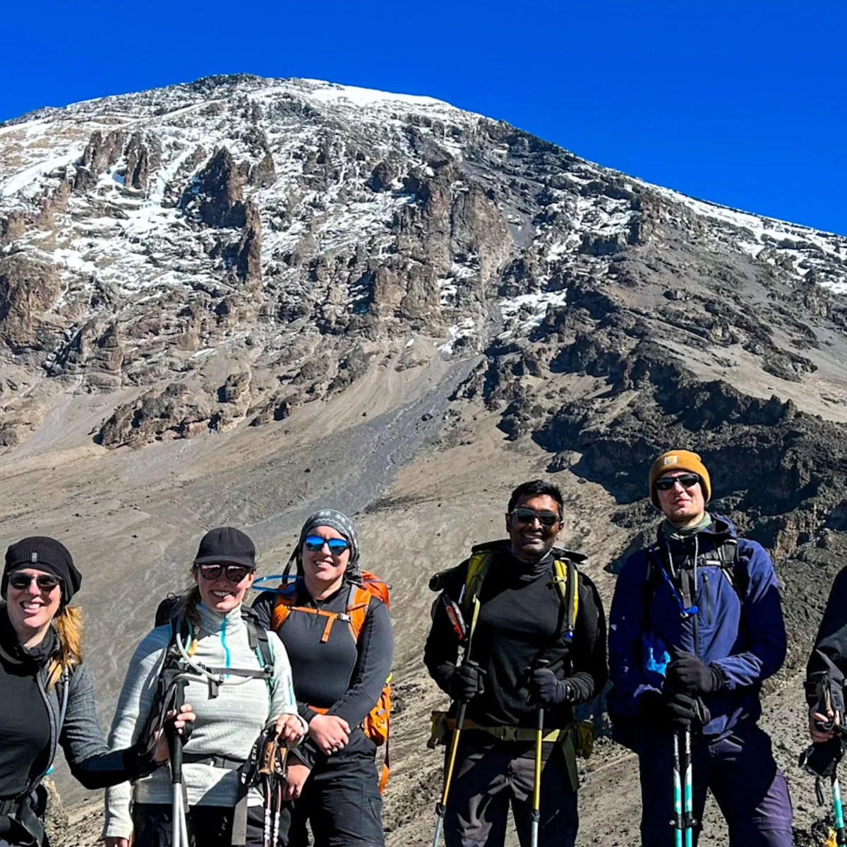 Three ladies taking a selfie at summit with glacier in background
