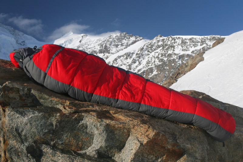 Winter sleeping bag red in snowy mountains
