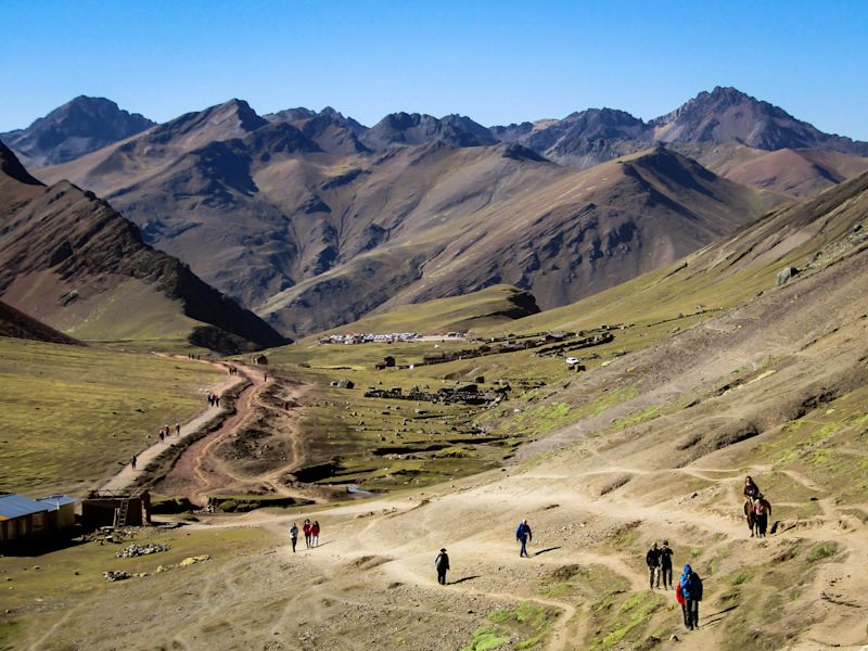 Hikers walk the road to Rainbow Mountain, a place very visited by tourists in Cusco, Peru.