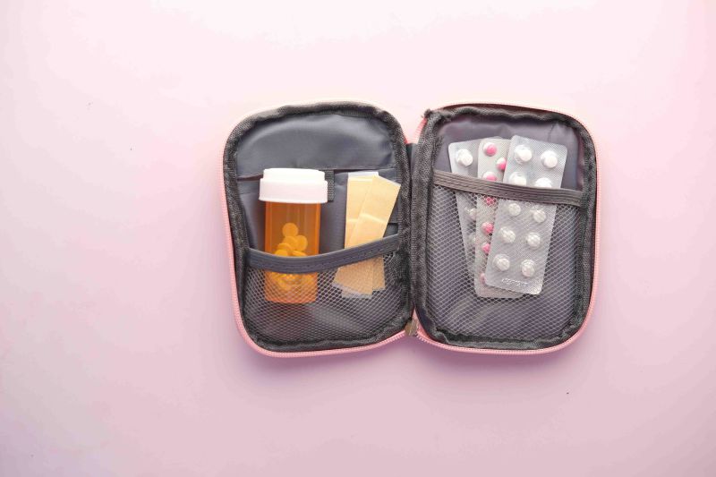 Small first aid kit against a pink background 