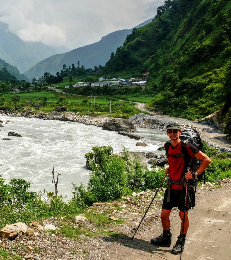 Ours. Trekker near river near to Besisahar town in Annapurna Circuit region, Nepal