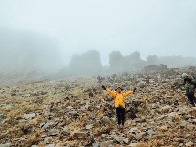 Happy climber in yellow jacket on Kilimanjaro in the mist