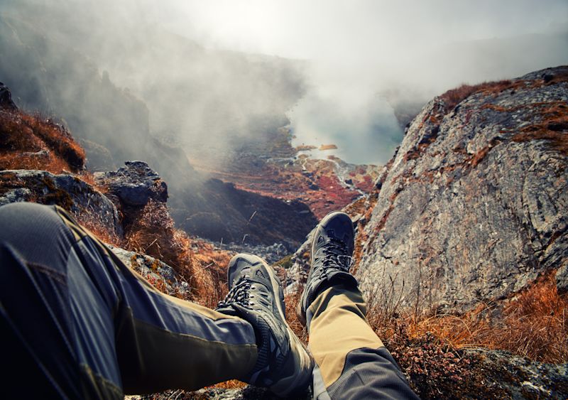 Hiking boots on trekker looking at mountain landscape in Nepal