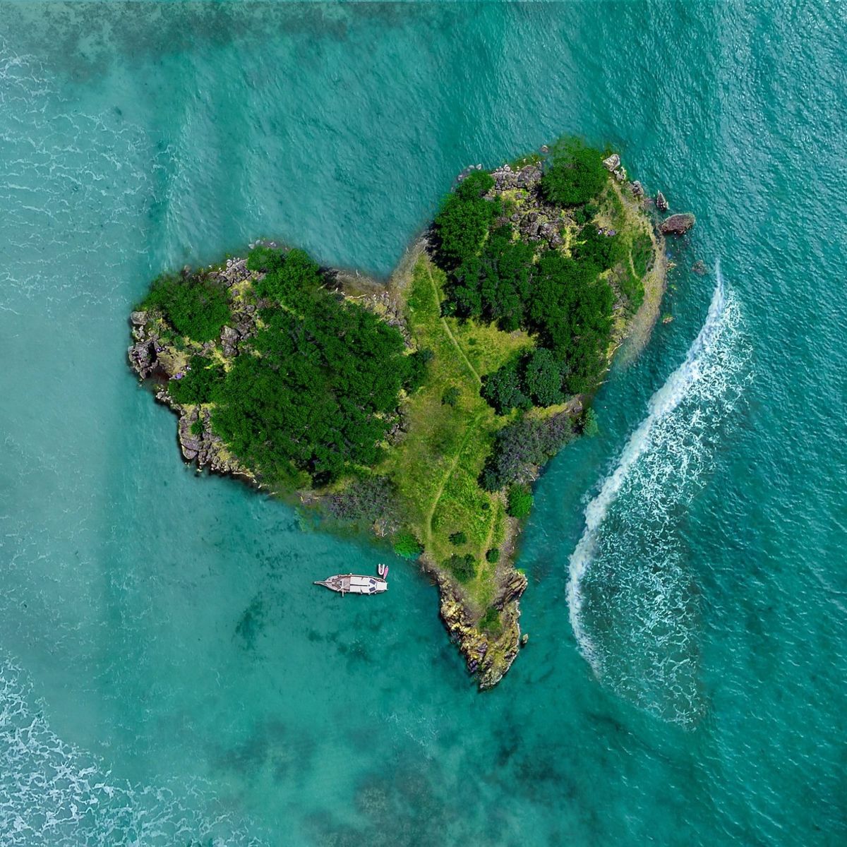 Heart-shaped island in blue sea, aerial view
