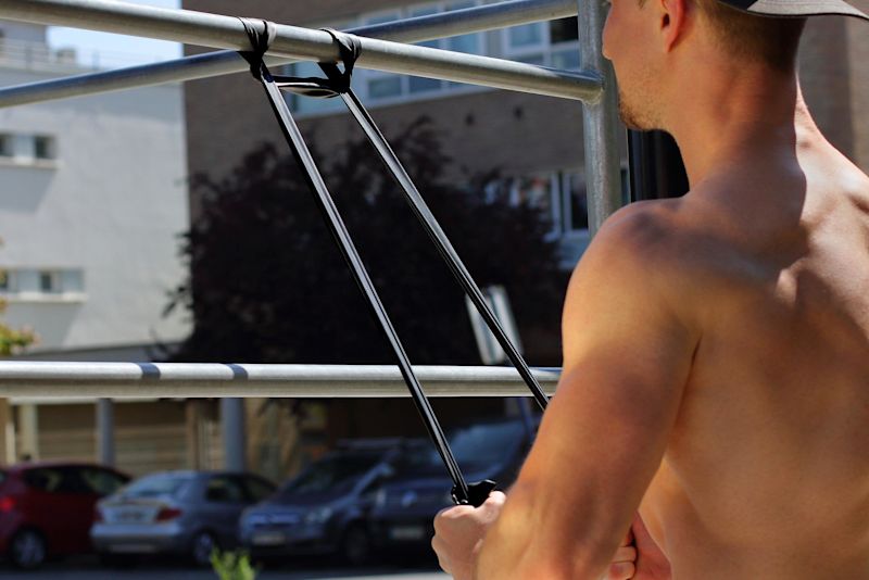 Man using resistance band to exercise outdoors