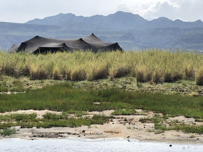 View of tent in Lake Natron Camp with escarpment behind, Tanzania