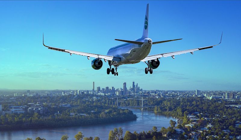 Boeing airplane flying low over green city and river